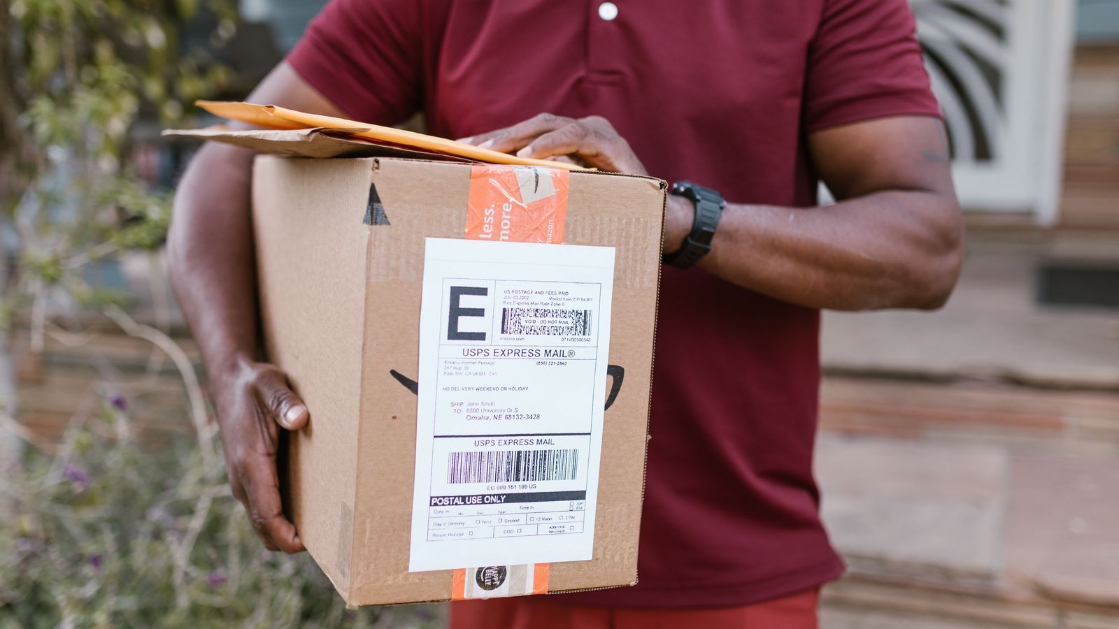 Courier holding a parcel with a shipping label