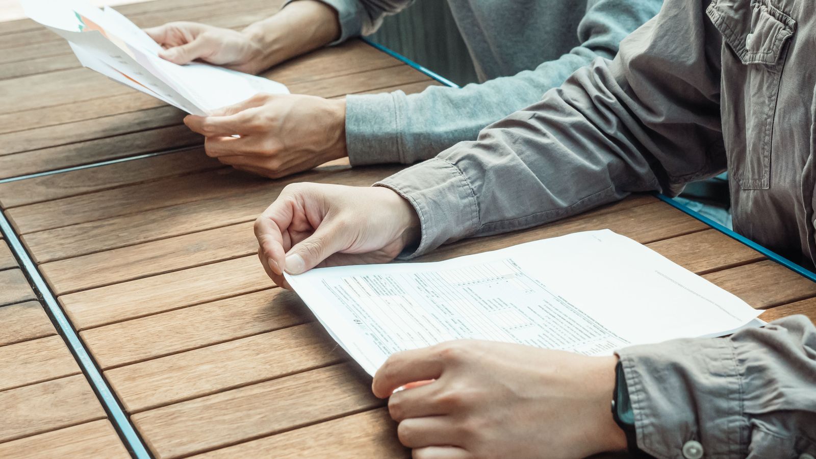 Two people comparing printed documents