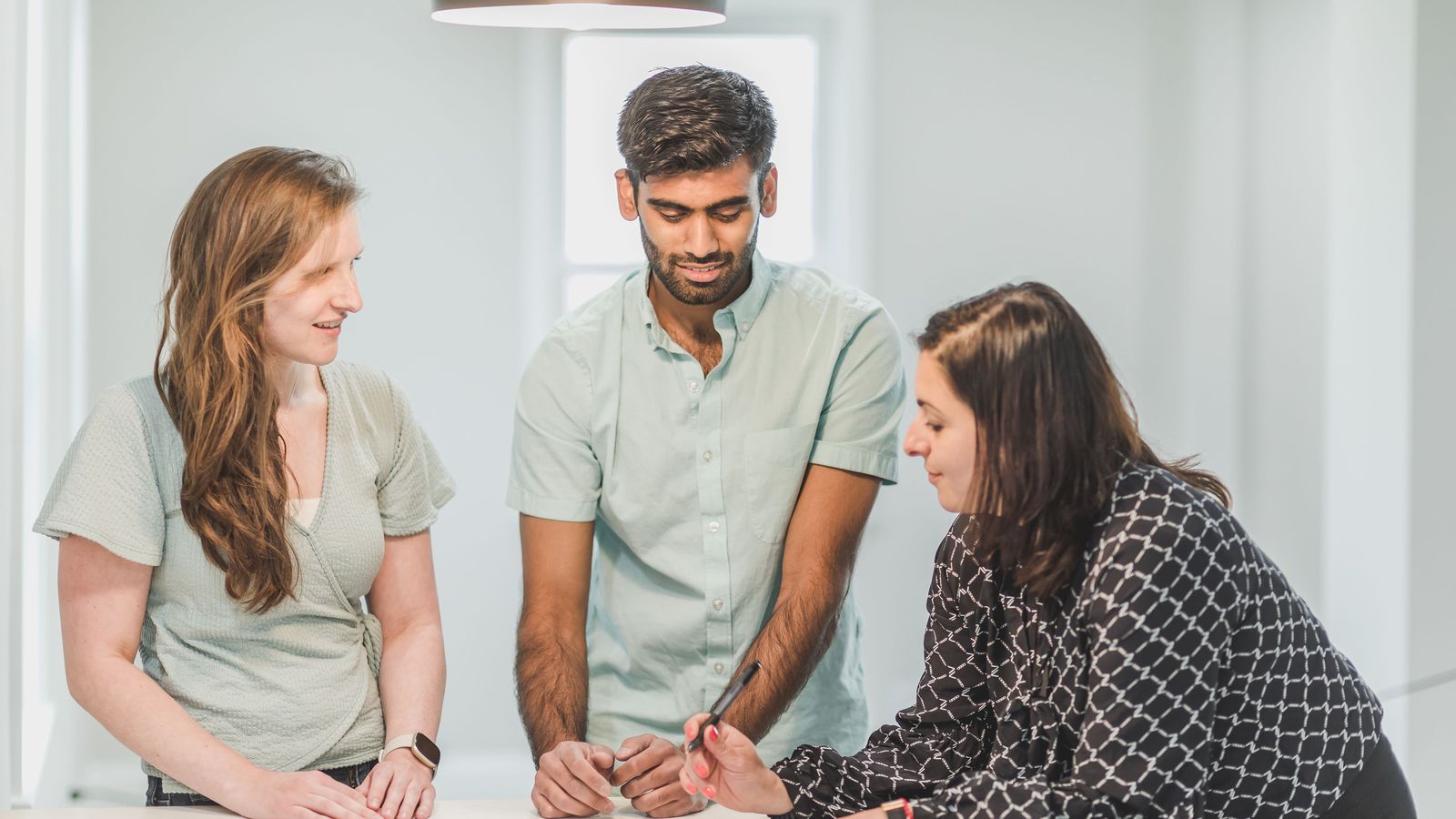Three colleagues reviewing documents at a table