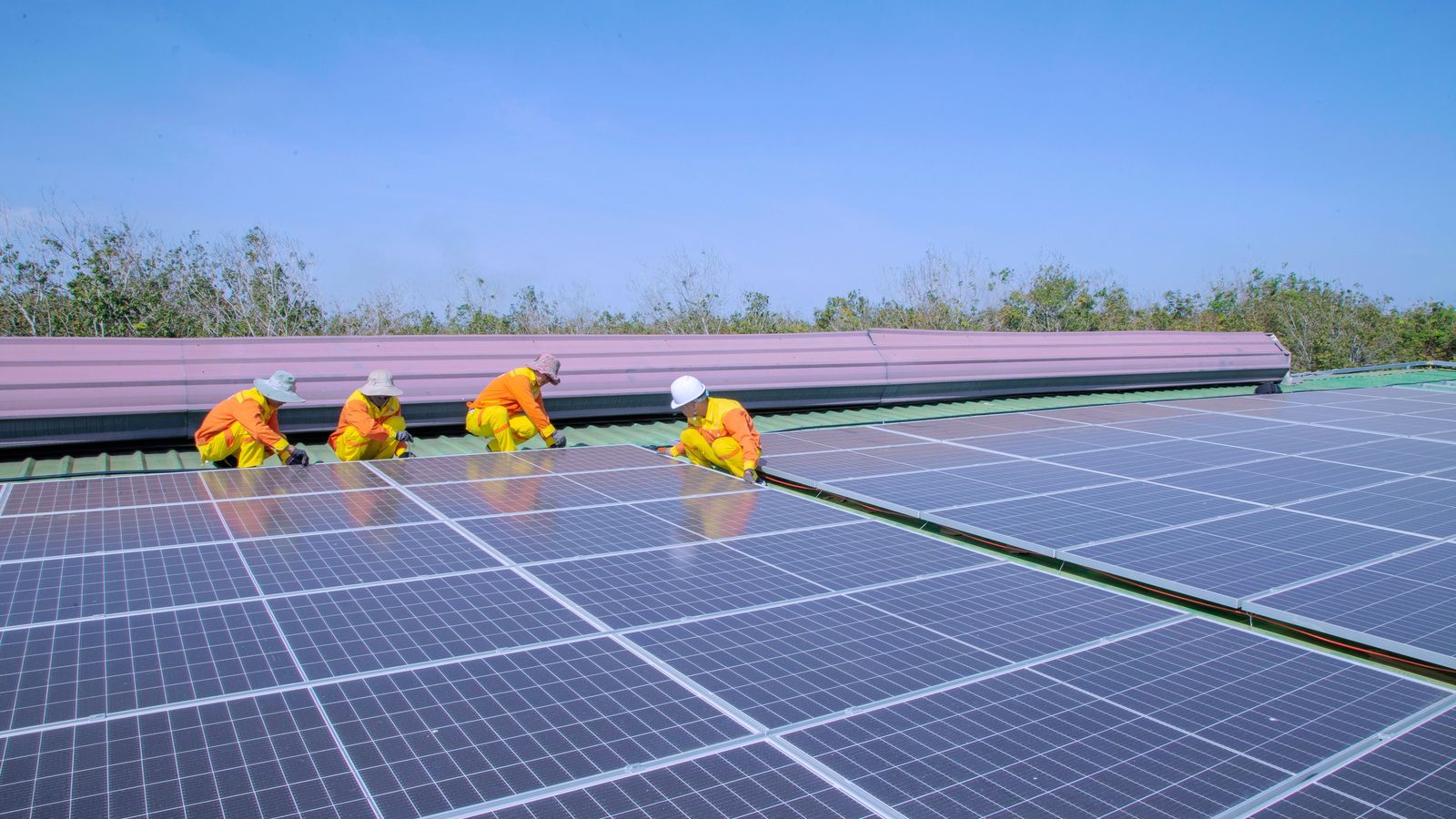 Workers installing rooftop solar panels